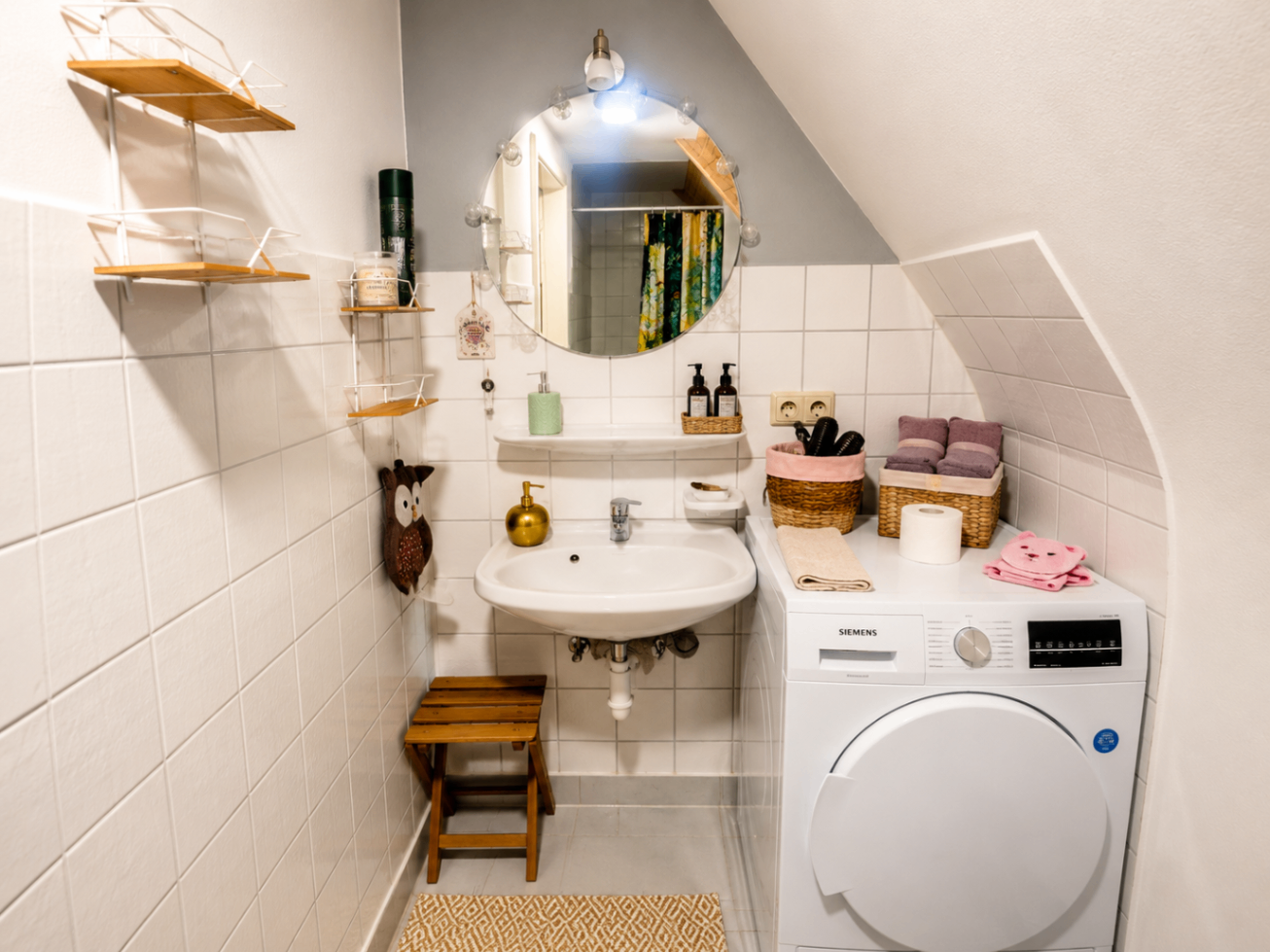 Bad mit Waschbecken, Waschmaschine und rundem Spiegel