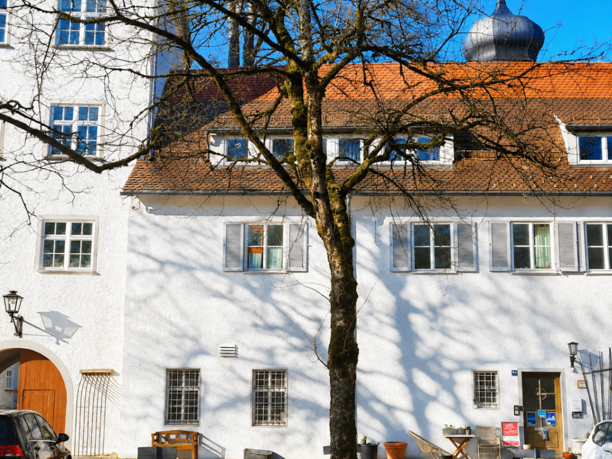Fassade des Schloss Isny mit Baum, Torbogen und Eingang zur Ferienwohnung