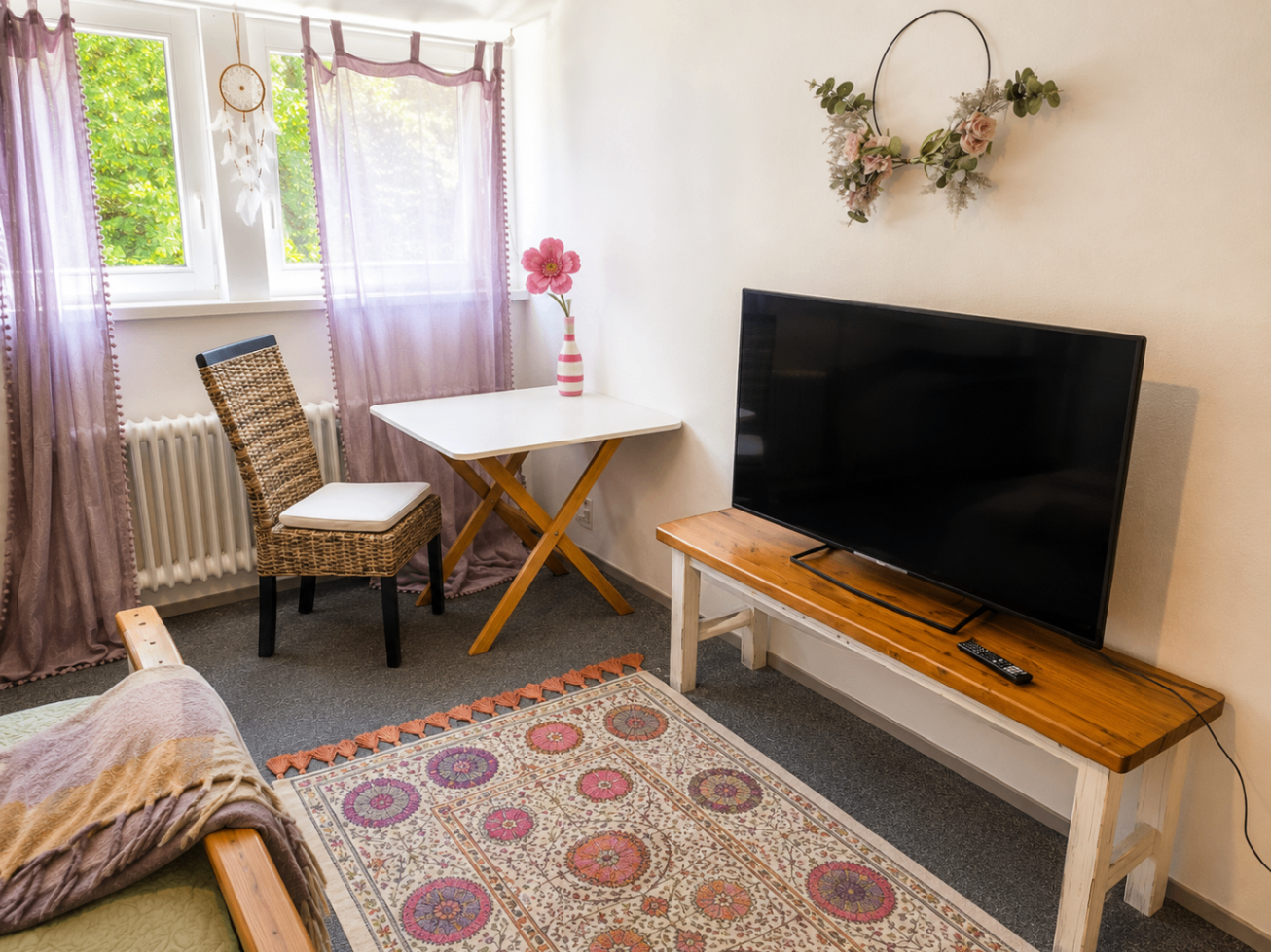 Bett mit Smart-TV und Handtüchern in der Purple Room