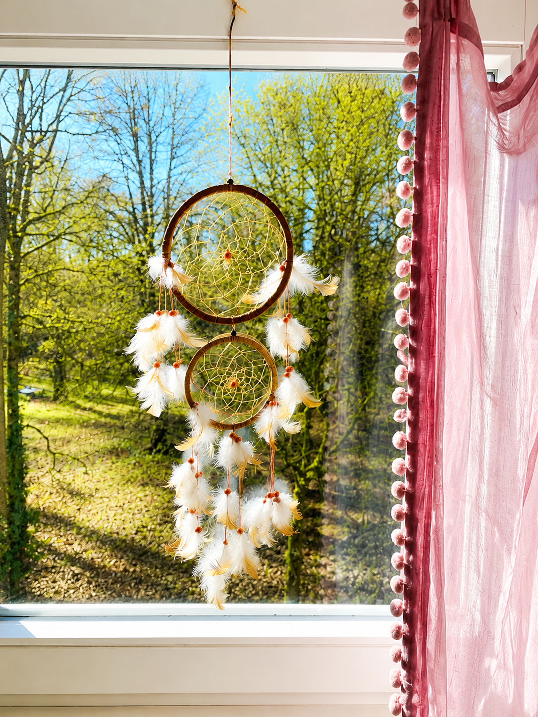 Traumfänger am Fenster mit Blick in den Schlosspark
